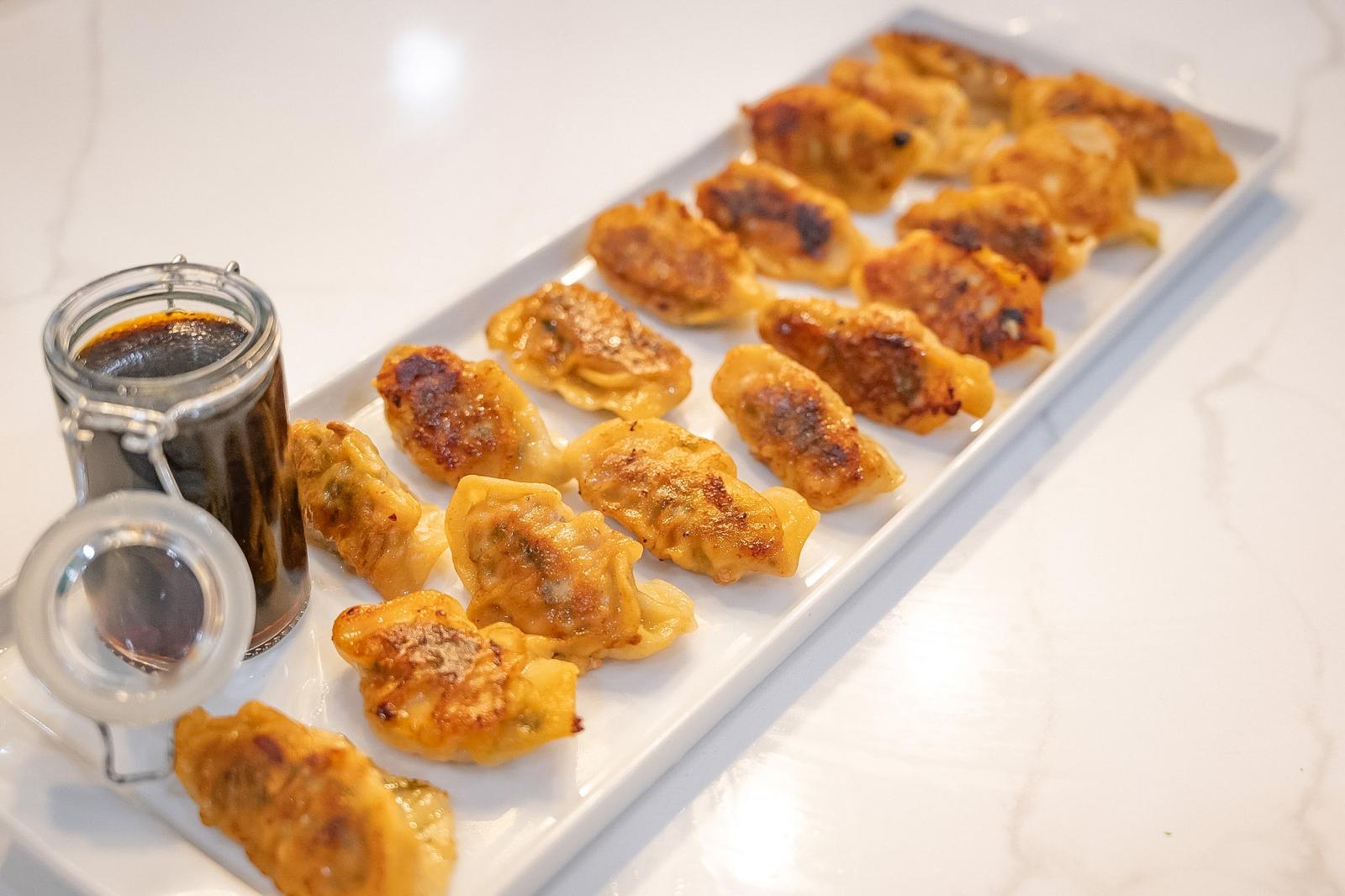 Golden dumplings arranged with a dipping sauce